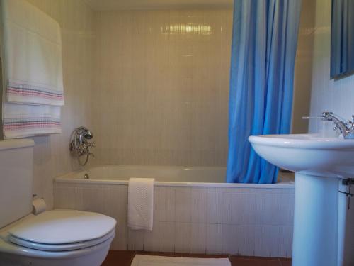 een badkamer met een toilet, een wastafel en een bad bij Casa de Pereiró in Soajo