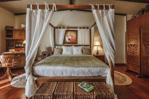 a bedroom with a canopy bed and a table at Finca Santa Maria in Callao Salvaje