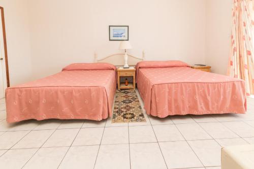 two beds sitting next to each other in a room at Rosewood Apartment Hotel in Arnos Vale