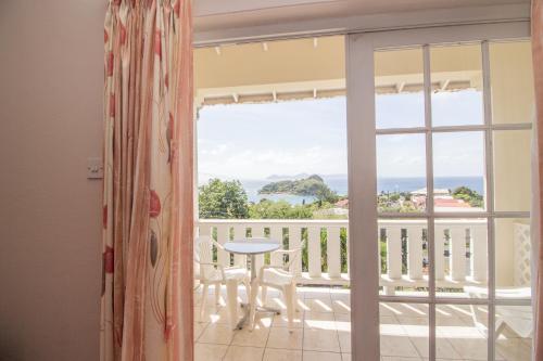 a room with a view of the ocean from a balcony at Rosewood Apartment Hotel in Arnos Vale
