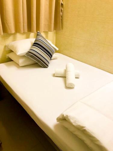 a bed with two towels and pillows on it at Holiday Guest House in Hong Kong