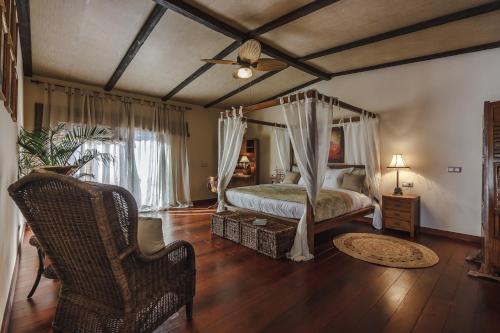 a bedroom with a canopy bed and a chair at Finca Santa Maria in Callao Salvaje