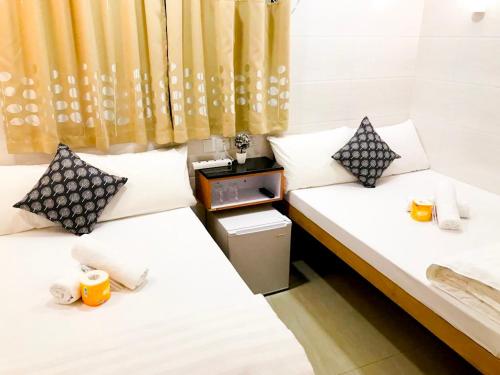 two beds sitting next to each other in a room at Holiday Guest House in Hong Kong