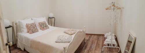 a bedroom with a white bed with pillows on it at A Casa de S. Vicente in Lisbon