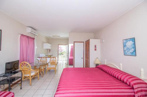a bedroom with a large pink bed in a room at Rosewood Apartment Hotel in Arnos Vale