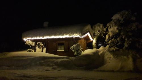 a house covered in snow at night with lights at Haus Baumgartner in Schattwald