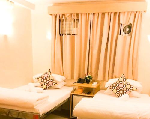 a room with two beds and a window at Holiday Guest House in Hong Kong