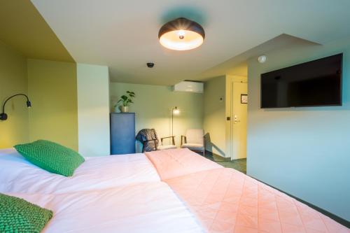 a bedroom with a large bed and a flat screen tv at LUDIEK eten en slapen in Havelte