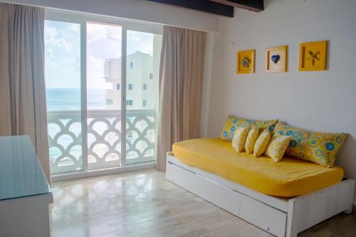 a bedroom with a yellow bed and a large window at BSEA Cancun Plaza Hotel in Cancún