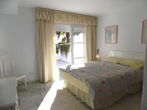 Un dormitorio con una cama grande y una ventana en Apartament - dom, Hiszpania Andaluzja, Costa del Sol, en Estepona