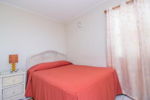 a bedroom with a bed with a red blanket at Rosewood Apartment Hotel in Arnos Vale