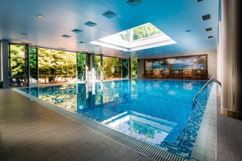 an indoor swimming pool with a large glass wall at Hemus Hotel - Vratza in Vratsa