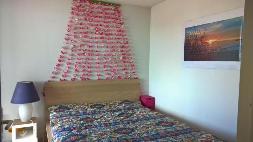 - une chambre dotée d'un lit avec un mur rouge dans l'établissement appartement 58 m 2 en 1 ere ligne ,vue mer panoramique ,2 terrasses dont une couverte résidence le Sunset, au Cap d'Agde