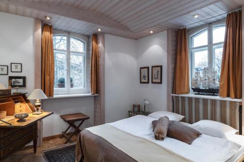 a bedroom with a bed and a desk and windows at Art Deco Villa Mon Abri BnB in Goldau
