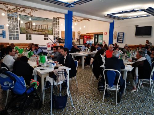 eine Gruppe von Personen, die in einem Restaurant an Tischen sitzen in der Unterkunft Hotel Kennedy in Metaponto