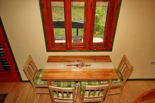 a table and chairs in a room with a window at Brvnara Zlatiborka in Zlatibor