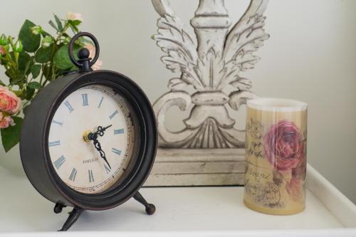 a clock sitting on a table next to a cup at Thistle Cottage in Ashburton
