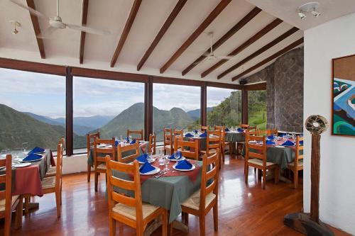 a restaurant with tables and chairs with mountains in the background at El Crater in San Antonio