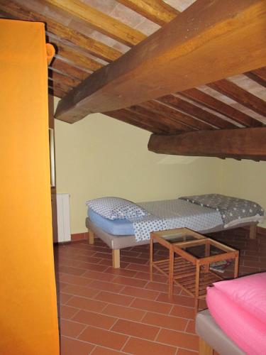 a room with two beds and a wooden ceiling at Casavacanze I PINI in Cerbaia