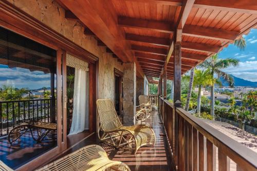 a porch with chairs and tables on a balcony at Finca Santa Maria in Callao Salvaje