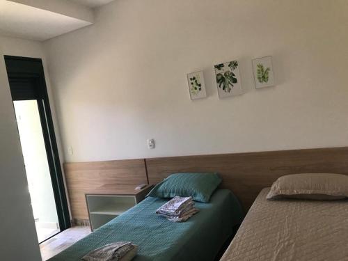 a bedroom with a bed with a green comforter at LINDO APARTAMENTO NA PRAIA GRANDE, UBATUBA in Ubatuba