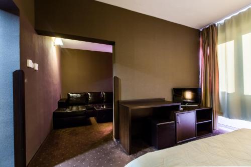 a hotel room with a bed and a couch at Hemus Hotel - Vratza in Vratsa