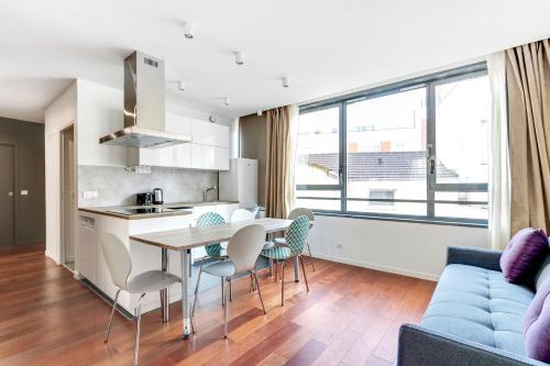 une cuisine et un salon avec une table et des chaises dans l'établissement Pick A Flat's Apartment rue Pajol - La Chapelle, à Paris