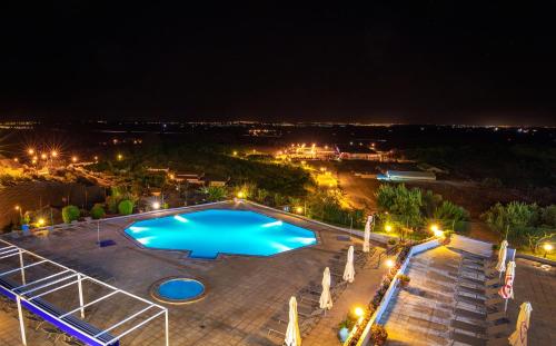 an overhead view of a large swimming pool at night at Santarem Hotel in Santarém