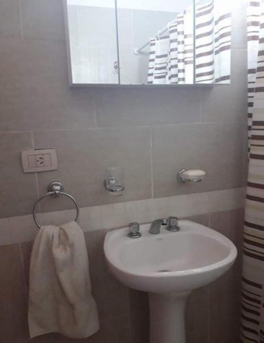 a bathroom with a sink and a mirror and a towel at Duplex en Valle Hermoso in Valle Hermoso