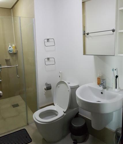 a bathroom with a toilet and a sink and a shower at Marquee Residences in Angeles