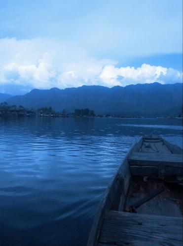 a boat sitting on the water next to a dock at Houseboat New Suzan in Srinagar