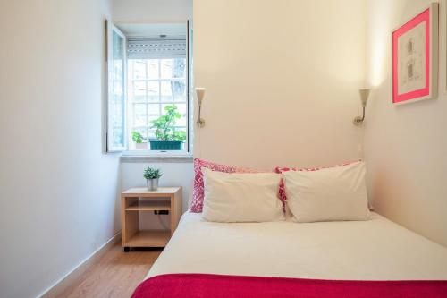a bedroom with a white bed with a red blanket at Casa da Praceta in Lisbon