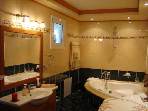 a bathroom with a tub and a sink and a bath tub at Eleni Apartments in Arillas