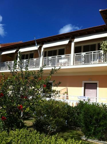 an apartment building with a balcony and bushes at Eleni Apartments in Arillas