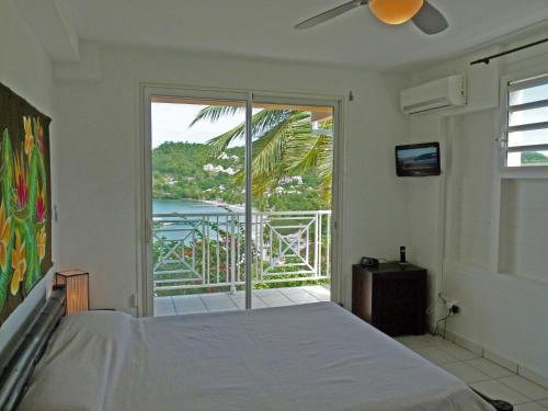 a bedroom with a bed and a view of the ocean at Ti ' Plage in Les Trois-Îlets
