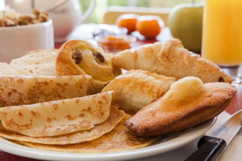 een bord ontbijtproducten met brood en toast bij The Originals City, Hôtel Castel Burgond, Dijon Ouest in Daix