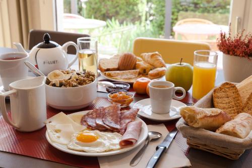 een ontbijttafel met eieren, brood en koffie bij The Originals City, Hôtel Castel Burgond, Dijon Ouest in Daix