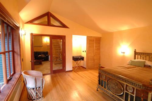 a bedroom with a bed and a chair in a room at YAN KEE WAY LODGE BUNGALOW in Puerto Varas