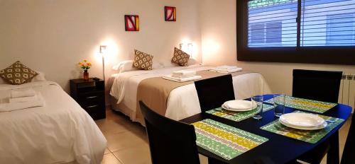 a hotel room with two beds and a table with plates at Umbral del Aconcagua in Mendoza