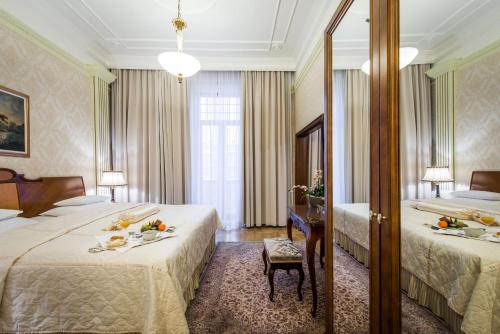 a hotel room with two beds and a table with food on it at Hotel Moskva in Belgrade