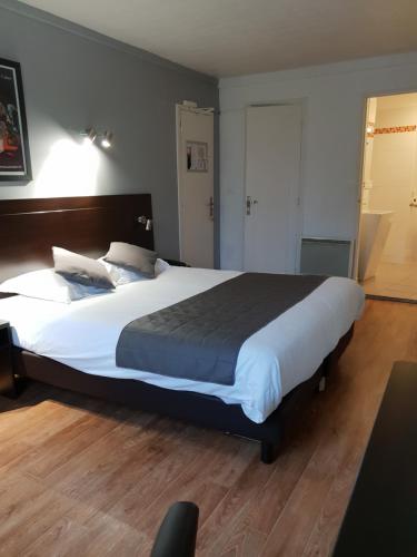 a large bed in a room with a large white bed sidx sidx sidx at Le Napoleon in Lille