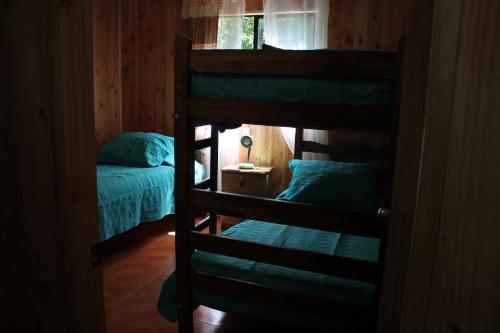 1 dormitorio con 2 literas y 1 cama en Cabañas Don Vittorio, en Caburgua