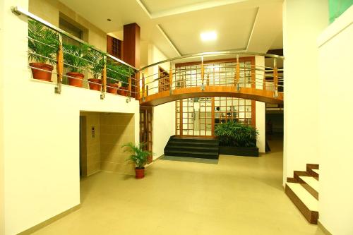 a hallway of a building with a staircase and potted plants at Hotel Pearl Palace in Cochin