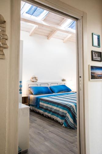 a bedroom with a bed with blue pillows at Mediterranean house in SantʼAntìoco