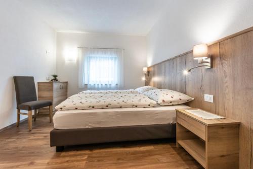 Un dormitorio con una cama grande con cabecero de madera. en Alfred Ties Apartments, en San Vigilio Di Marebbe