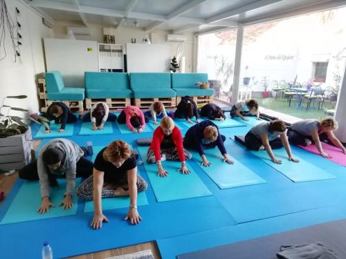 a group of girls doing yoga on a blue yoga floor at Casa de Huéspedes con encanto El Sueño del Quijote in Alcalá de Henares