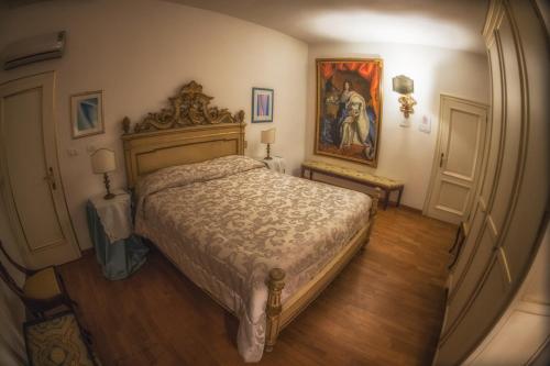 - une chambre avec un lit et une peinture murale dans l'établissement Antica Dimora Conti Custoza, à Roverbella