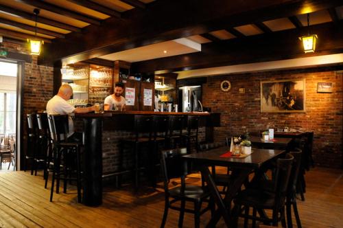 dos hombres sentados en un bar en un restaurante en Vakantiewoning Zavelbos, en Maaseik