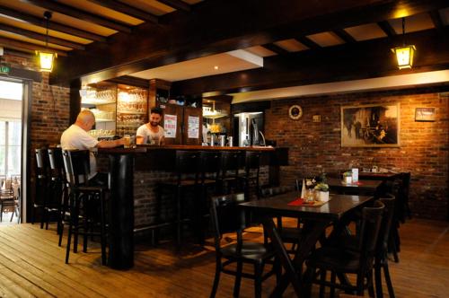 two men sitting at a bar in a restaurant at Vakantiewoning Zavelbos in Maaseik