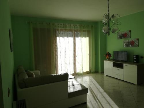 un soggiorno verde con divano e finestra di GIARDINO DI PRIMAVERA a Bagnoregio
